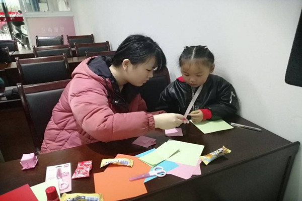 干事教小朋友折风车